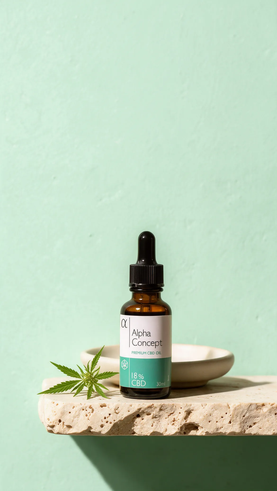 Bočica Alpha Concept CBD ulja 18% na travertinskoj polici uz list konoplje, ispred mint zelenog zida